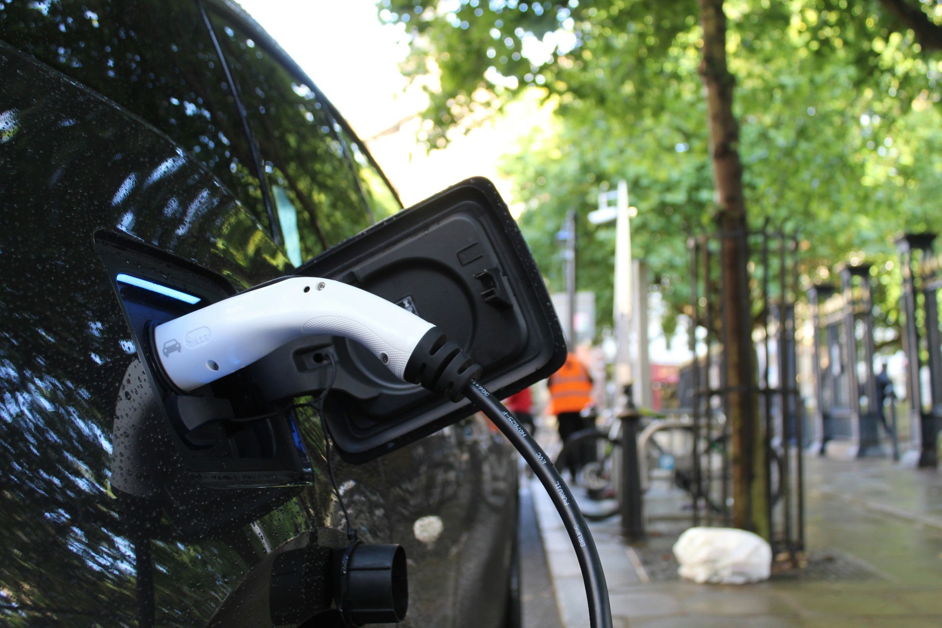 EV charger plugged into a vehicle at a curbside charging station